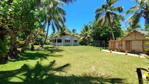 a yard with a house and palm trees at Villa Ste Marie in Sainte Marie