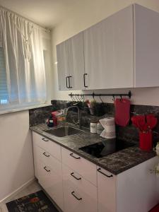 a kitchen with white cabinets and a sink at Franz home and FREE parking Wi-Fi AC in Bolzano