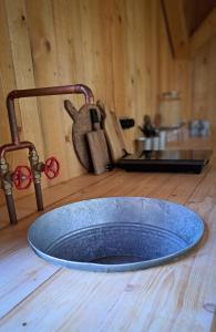 einen Wasserhahn und eine blaue Schüssel auf einem Holztisch in der Unterkunft Na seně in Kozlovice