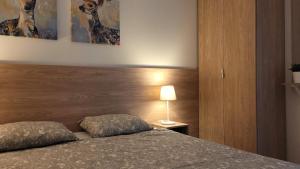 a bedroom with a bed with a wooden headboard and a lamp at Apartament Korczaka 6 in Śrem