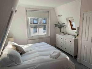 ポーツマスにあるA charming home in the heart of Southseaの大きな白いベッドと窓のある寝室