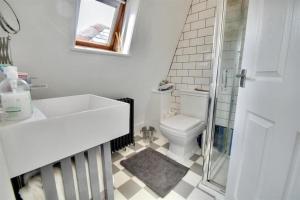 ポーツマスにあるA charming home in the heart of Southseaの洗面台とトイレを備えた白いバスルーム +21枚の写真