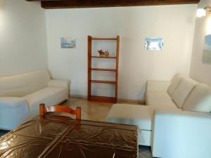 トラッペートにあるCasa Vacanze a 100 m dal mareのリビングルーム(白い家具、テーブル付)