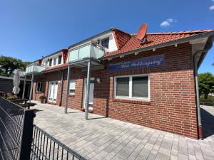 un edificio di mattoni rossi con un cartello sopra di Haus Hobbingshof Greetsiel a Greetsiel