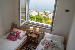 a small room with two beds and a window at Apartman Gratitude in Rijeka