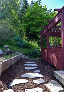 einen Garten mit Steinpfad und Holzkonstruktion in der Unterkunft Villa with mountain view in the Swedish High Coast in Docksta