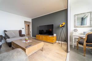 a living room with a flat screen tv and a couch at Apartman Gratitude in Rijeka