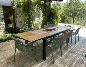 einen Holztisch und Stühle auf einer Terrasse in der Unterkunft Casale del Pozzo-Villa with pool - Fosdinovo in the borgo of Pulica in Tendola
