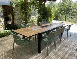 a wooden table and chairs on a patio at Casale del Pozzo-Villa with pool - Fosdinovo in the borgo of Pulica in Tendola