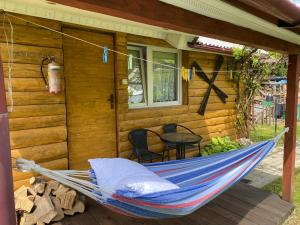 a hammock on the porch of a cabin at Bieszczady Smolnik Cottage in Smolnik +12 photos