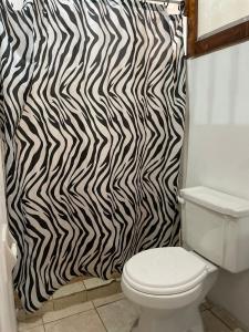 baño con cortina de ducha de cebra blanca y negra en Hospedaje Casa Amazónica Iquitos, en Iquitos