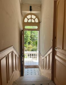 un couloir vide avec une porte ouverte et une fenêtre dans l'établissement Villa Bourgoise chez Perette à 7 mn en voiture de la croisette, à Cannes