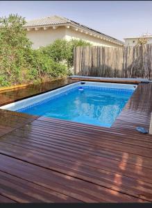 una piscina en la parte superior de una terraza de madera en צימר מול השקיעה, en Retamim