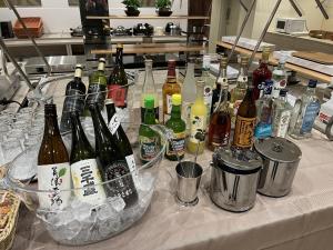 uma mesa com muitas garrafas de álcool em Kuretake Inn Premium Tajimi Ekimae em Tajimi