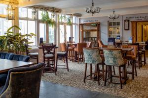 un restaurante con mesas, sillas y ventanas en White Lion Royal Hotel, en Bala