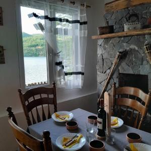 a table with a bottle of wine and a window at Vikend kuća Zlatarski DAR in Nova Varoš