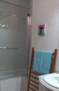 ヴィラ・ノヴァ・デ・ガイアにあるOporto Vasconcelos Guest Houseのバスルーム(シャワー、椅子に青いタオル付)