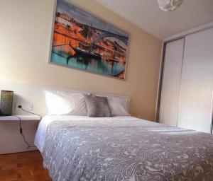 ヴィラ・ノヴァ・デ・ガイアにあるOporto Vasconcelos Guest Houseのベッドルーム1室(壁に絵画が描かれたベッド1台付)