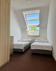 two beds in a room with a window at Ośrodek Wczasowy Walcownik in Sianozety