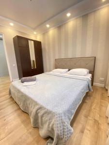 een slaapkamer met een groot bed met een deken erop bij Апарт Отель in Poti
