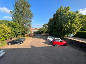 eine Gruppe von Autos, die auf einem Parkplatz geparkt sind in der Unterkunft All Seasons Gatwick Guest House & Parking in Horley