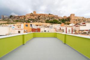 a green balcony with a view of a city at La Casa Verde in Almería