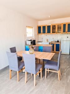eine Küche und ein Esszimmer mit einem Holztisch und Stühlen in der Unterkunft Apartment Gulić in Rab