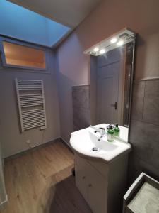 ein Badezimmer mit einem weißen Waschbecken und einem Spiegel in der Unterkunft Appartement centre ville, parking gratuit in La Rochefoucauld