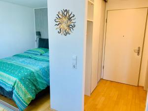 ein Schlafzimmer mit einem Bett und einer Wand mit einer Uhr in der Unterkunft AnNa Home & Sunny Home Apartments in Karlsruhe