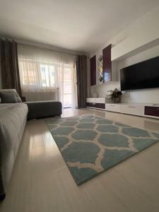 ein Wohnzimmer mit einem Sofa und einem TV in der Unterkunft Dem ‘LuxuryApartmens in Râmnicu Vâlcea