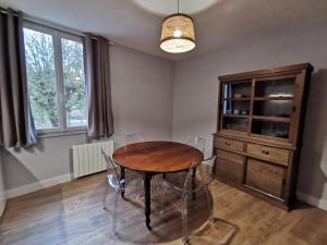 ein Esszimmer mit einem Holztisch und einer Kommode in der Unterkunft Appartement centre ville, parking gratuit in La Rochefoucauld