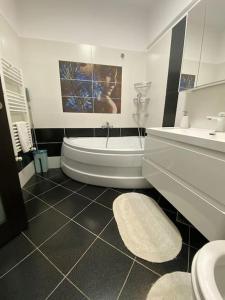 a bathroom with a tub and a toilet and a sink at Dem ‘LuxuryApartmens in Râmnicu Vâlcea