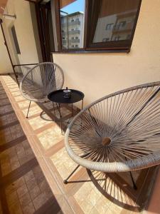 two chairs and a table next to a wall at Dem ‘LuxuryApartmens in Râmnicu Vâlcea