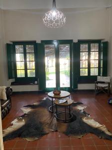 sala de estar con mesa y lámpara de araña en Estancia Santa Margarita 1873 en Junín