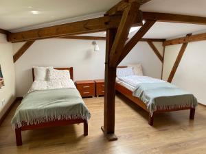 two twin beds in a room with wooden beams at Pokoje u świętego Krzysztofa in Wrocław