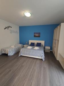 Un dormitorio con dos camas y una pared azul. en 'O Vuzze d'o Mast, en Sorrento