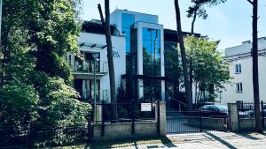 a building with a glass facade with a fence at Aqua Villa 4 in Jurata