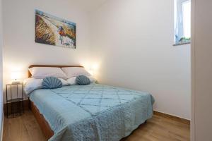 een slaapkamer met een bed met een blauwe deken bij Apartman Pepa Split (Žrnovnica) in Žrnovnica
