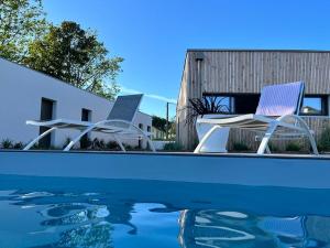 two chairs sitting next to a swimming pool at Entre Mer & Filles in Sainte-Soulle +22 photos
