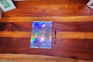 a book sitting on top of a wooden table with a pen at Chez Eden Coconut Studio in Papeete