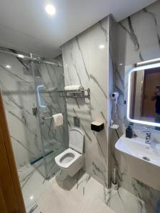 a bathroom with a shower and a toilet and a sink at appart hotel puerto marino in Al Hoceïma