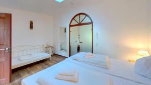 a white bedroom with two beds and a mirror at Las Fincas Baabe in Baabe