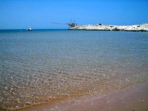 un bacino d'acqua con spiaggia e mulino a vento di Villaggio Turistico Scialmarino a Vieste