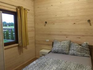 a bedroom with a bed and a window at Przytulisko na Mazurach in Ruciane-Nida