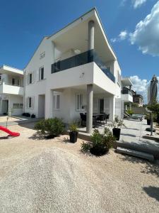 a large white house with a red slide in front of it at Haus Dalmatia with heated Pool in Bibinje