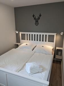 - un lit blanc avec des serviettes blanches dans l'établissement Ruhiges Ferienhaus mit Sauna: Hellaberg III, à Langenbach
