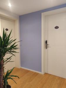 a white door in a room with a plant at Alfea Deluxe Loft & Rooms in Trento