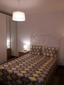 a bedroom with a bed with a patterned bedspread at La casita de la playa in Ribeira