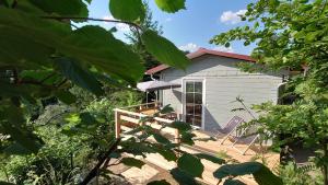 ein kleines Haus mit einer Terrasse und einer Veranda in der Unterkunft Ruhiges Ferienhaus mit Sauna: Hellaberg III in Langenbach