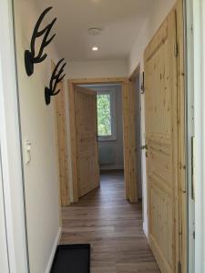 a hallway with wooden doors and antlers on the wall at Ruhiges Ferienhaus mit Sauna: Hellaberg III in Langenbach